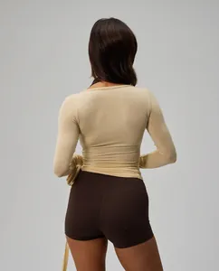 Back view detail of long sleeve ballet-style yoga wrap top in cream and brown