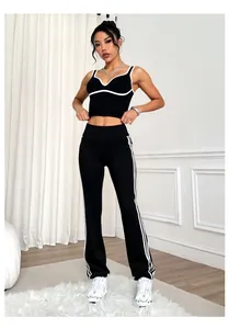 Sporty black and white contrast yoga set featuring flared pants and side stripes on model
