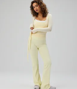 Close-up detail of pale yellow ballet style yoga wrap top and flared pants on model