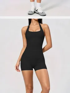Détail d'un haut de yoga dos nu sans couture noir et d'un short de sport assorti sur modèle.
