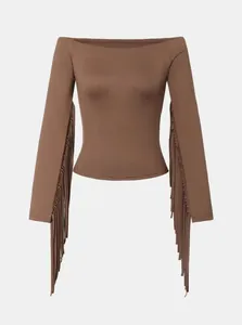 Detailed view of a brown off-the-shoulder long sleeve top with western style fringe.