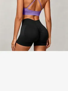 Back detail view of seamless black scrunch butt yoga shorts with a purple bra