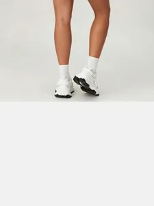 Back view of white athletic sneakers and white socks as a detail for tennis dress outfit