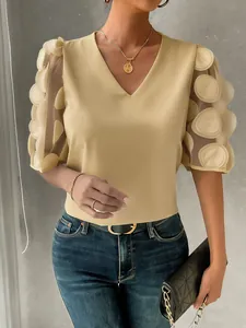 Detail view of a yellow sheer bubble sleeve blouse with 3D dot appliques and V-neck