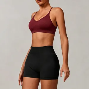 Seamless knit burgundy yoga sports bra and black high-waisted shorts set on model