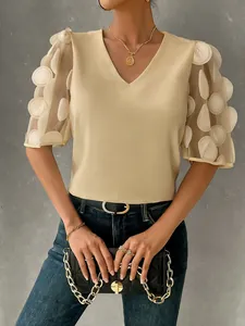 Close-up detail of a V-neck beige blouse featuring unique 3D applique mesh puff sleeves