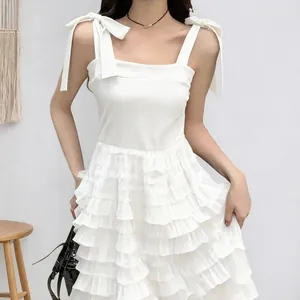 Elegant white sleeveless tiered mesh dress with spaghetti straps and ruffles.