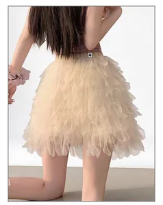 Détail montrant le design des volants superposés d'une jupe courte en tulle beige.