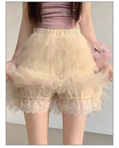 Gros plan montrant le jupon en tulle beige superposé et l'ourlet en dentelle délicate.