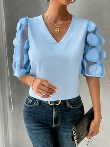 Detail view of women's light blue V-neck blouse featuring 3D dot mesh puff sleeves