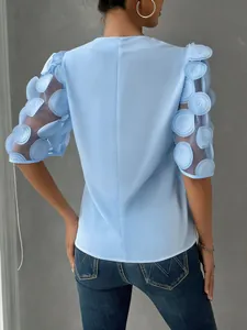 Detailed back view of a light blue blouse featuring 3D applique mesh puff sleeves