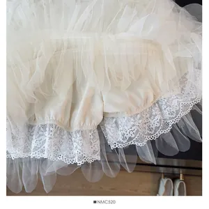 Gros plan détaillé d'une jupe-short en tulle blanc multicouche avec bordure en dentelle