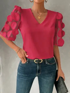 Red V-neck blouse featuring 3D mesh puff sleeves with textured circular patterns.