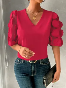 Close-up detail of a red V-neck blouse featuring unique 3D dot mesh bubble sleeves.