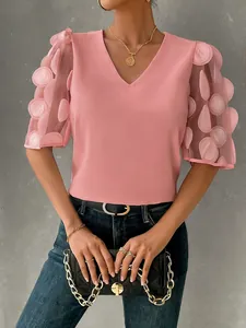 Detailed view of women's pink V-neck blouse with sheer 3D dot mesh puff sleeves