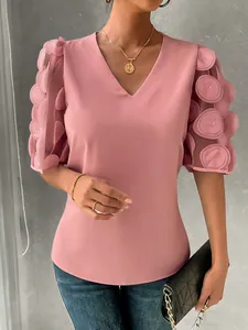 Detailed view of V-neck top showing pink fabric and sheer puff sleeves with dot textures.