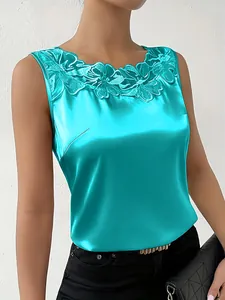 Detalle de blusa de satén sin mangas turquesa con elegante bordado de encaje