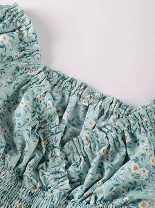 Close-up of floral print dress detail with ruffled edge and size S label