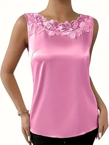Detalle en primer plano de la camiseta de satén rosa con bordado floral de encaje