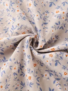 Detailed macro view of vintage floral print fabric texture with blue and orange flowers.