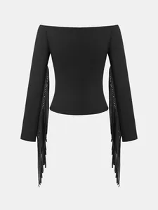 Detailed view of the long fringe on a black off-the-shoulder western style top.
