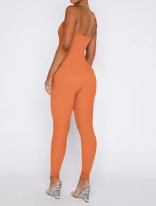 Back view of orange ribbed backless jumpsuit with spaghetti straps on model