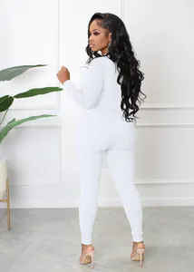 Back view of a sleek white ribbed long-sleeve zipper athletic jumpsuit shown on a model