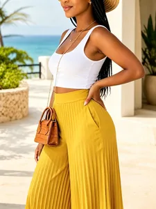 High-waisted mustard yellow pleated wide-leg trousers for a stylish summer vacation look.