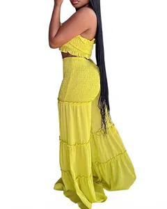 Detalle de top corto fruncido amarillo y pantalones anchos con volantes para mujer