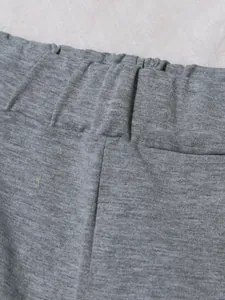 High-quality close-up showing the elastic waistband detail of grey sporty sweatpants