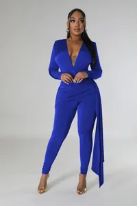 Elegant side draping detail on a royal blue bodycon jumpsuit with long sleeves