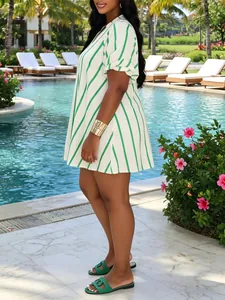 Detalle del vestido corto de rayas verdes para mujer en la zona de una piscina tropical