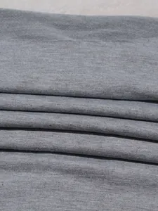 Close-up detail shot of grey knitted fabric showing soft jersey texture and weave.