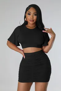 Detailed view of women's black two-piece set with crop top and ruched bodycon skirt