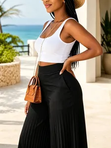 Detail of black high-waisted pleated wide-leg trousers for a stylish summer resort look.