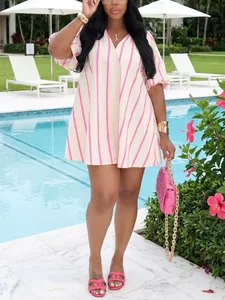 Mujer elegante con minivestido de rayas rosas con escollo en V y mangas abullonadas en la piscina