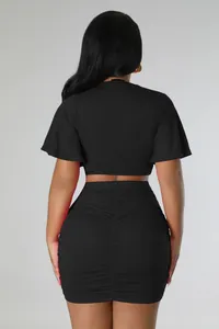 Back view of black two-piece set featuring crop top and ruched bodycon skirt