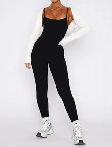 Detail of chic black spaghetti strap jumpsuit paired with white ribbed knit shrug bolero