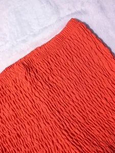 Macro de la textura de la tela fruncida naranja para un top bandeau de verano de mujer