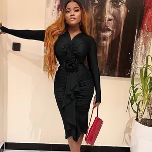 Detailed view of elegant black long sleeve bodycon dress with rose accent and ruching