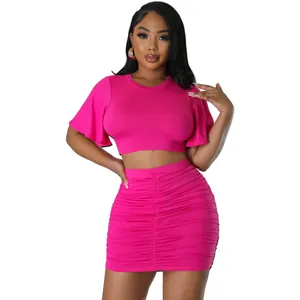 Front view of hot pink two-piece set featuring crop top and ruched mini skirt