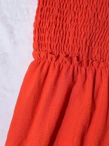 Detalle del corpiño fruncido y cintura con volantes en conjunto casual rojo de dos piezas