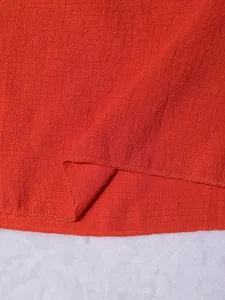Detalle macro de la tela roja texturizada y costura del dobladillo de un conjunto de verano
