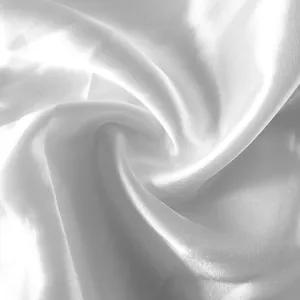 Détail en gros plan d'un tissu satiné blanc présentant une texture plissée élégante et soyeuse