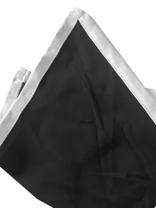 Primer plano detallado de mono bicolor con ribete blanco sobre tejido negro liso