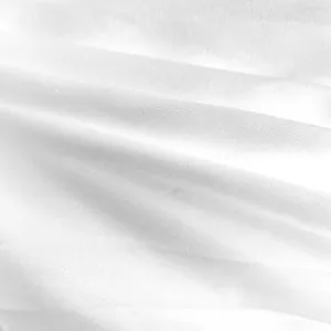 Vue macro détaillée de la texture du tissu plissé blanc pour une robe longue grande taille