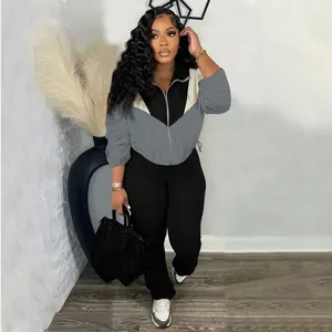 Stylish women's two-piece tracksuit featuring color-blocked zip-up jacket and black leggings.