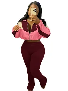 Two-piece pink and burgundy patchwork sports set featuring a zip-up jacket and flare pants