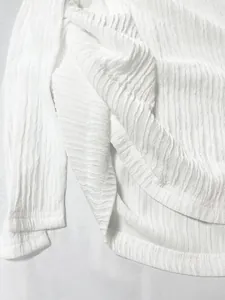 Dettaglio del tessuto bianco stropicciato traspirante per abbigliamento da spiaggia