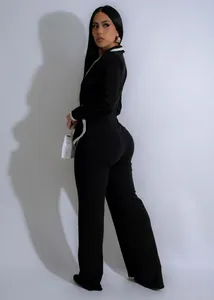 Elegante mono negro de manga larga con ribete de contraste blanco y diseño de cinturón